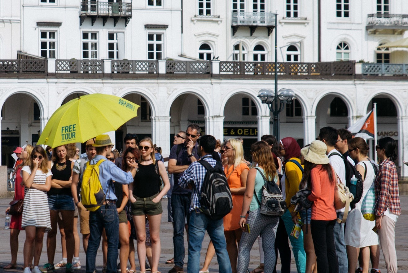 Deutscher-Stadtführer-über-Guruwalk-Hamburg Deutscher Stadtführer mit gelbem Schirm spricht über Guruwalk Hamburg
